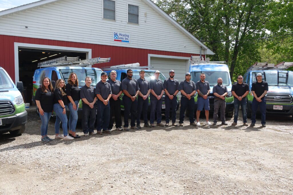 DK Heating Team standing in front of a building